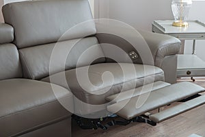 Modern grey leather sofa, with recliner in open position.