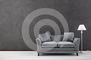 Modern grey sofa on grey wall background. Free space