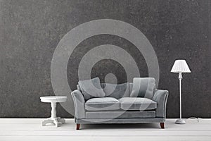 Modern grey sofa on grey wall background. Free space