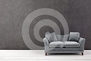 Modern grey sofa on grey wall background. Free space