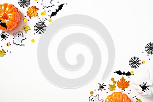 Modern Halloween background with pumpkins, bats, spiders, webs, ghosts, decorations on white table. Halloween party invitation