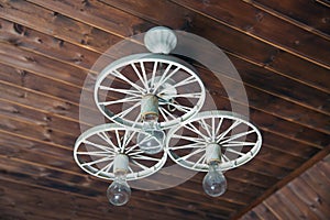 Modern Hanging Lamp Art And Science. Old vintage lighting decor. Lights made of white iron horse-drawn carriage . group