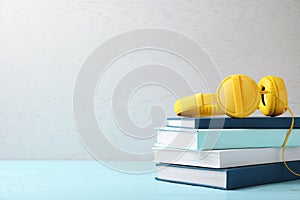 Modern headphones with hardcover book on table.