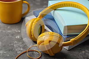 Modern headphones with hardcover books on table, closeup.