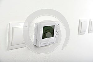Modern heat thermostat on a white background