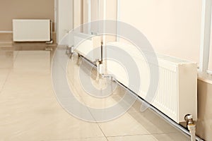 Modern heating radiators near closed windows photo