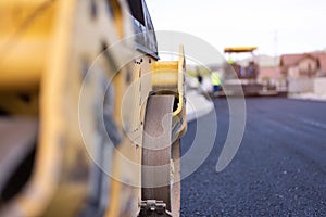 Modern heavy asphalt roller that stack and press hot asphalt. Yellow road repair machine. Repairing in modern city with vibration