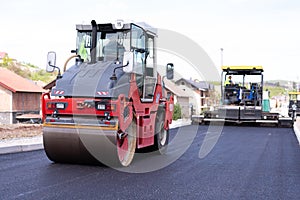 Modern heavy asphalt roller that stack and press hot asphalt. Yellow road repair machine. Repairing in modern city with vibration