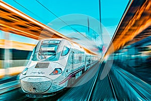 Modern hi-speed passenger train of Spanish Railways Company - Renfe, in  movement motion photo