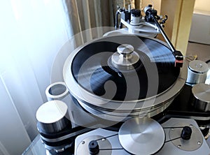 Modern high-precision record player with a rotating disc with an installed vinyl record
