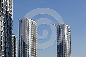 Modern high-rise buildings made of concrete and glass. Construction site. The final stage of construction. Against the background photo