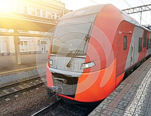 Modern high speed red commuter train at railway platform
