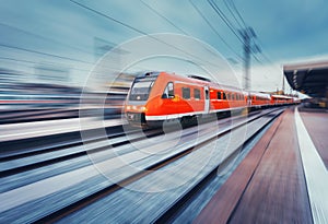 Modern high speed red passenger commuter train. Railway station