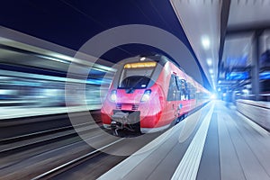 Modern high speed red passenger train at night