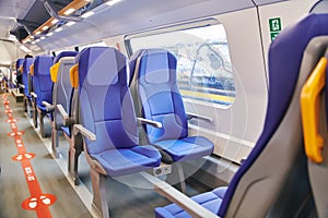 Modern high speed train interior with empty blue seats