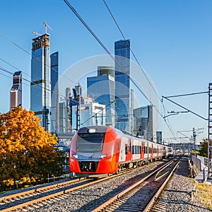 Modern high-speed train moves on the business center background.