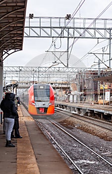 Modern high-speed train moves fast along the platform.