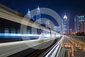 Modern high speed train at night. Fast train in city with motion blur effect, Public transport. Railway transportation