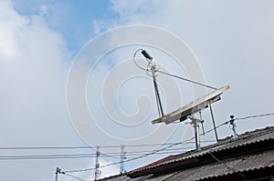 Modern high technology satellite on a roof with cloudy sky
