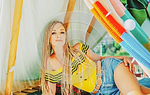Modern hippie girl in tent. Bohemian style. Woman outdoor fashion. Sunny portrait.