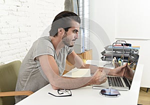 Modern hipster style student or businessman working in stress with laptop at home office angry upset