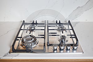 Modern hob gas or gas stove made of stainless steel using natural gas or propane for cooking products on light stoneware