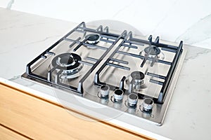 Modern hob gas or gas stove made of stainless steel using natural gas or propane for cooking products on light stoneware