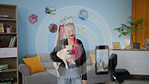 modern hobbies, stylish girl with pink braids and chihuahua dog shoots video content for popular social networks on