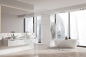 Modern home bathroom interior with bathtub, double sink and panoramic window