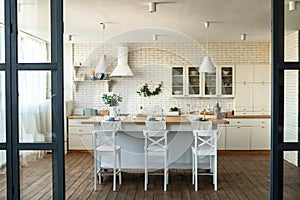 Modern home decor, interior design. Contemporary kitchen and dining room interior with table, chairs and comfy furniture