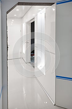 Modern home hallway interior. White plactic panels and tiles. Futuristic interior concept design. Space ship at home.