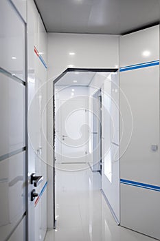 Modern home hallway interior. White plactic panels and tiles. Futuristic interior concept design. Space ship at home.