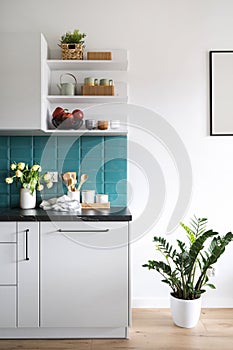 modern home kitchen with utensils, kitchenware and vase with flowers