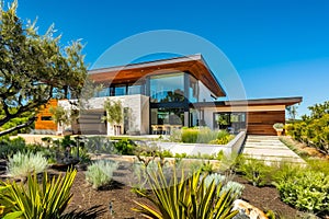 A modern home with landscaping and trees