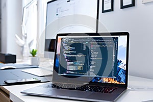 Modern Home Office Setup With Computer Code On Laptop Screen