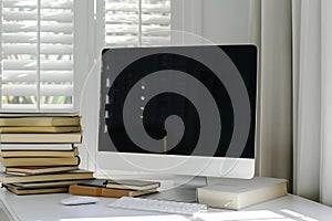 Modern Home Office Workspace: Computer, Books, and Natural Light