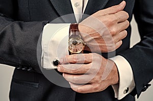 Modern horology. Wrist watch worn with formal suit. Portable timepiece. Time management. Horology concept. Professional