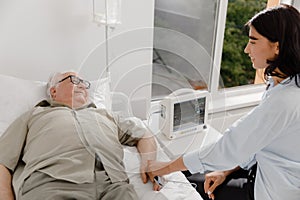 Modern hospital old man patient have a health checkup he wearing finger heart rate monitor pulse showing on the monitor