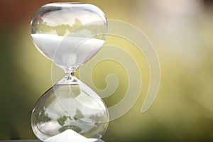 Modern hourglass on green background.