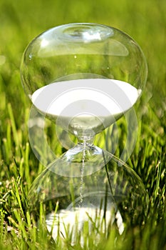 Modern hourglass on green background.