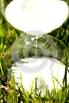 Modern hourglass on green background.