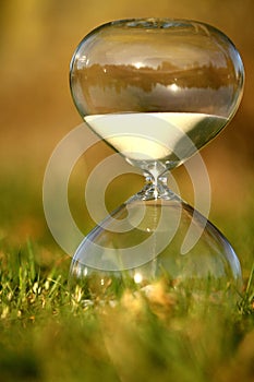 Modern hourglass on green background.