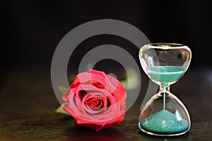 Modern hourglass and red rose with copy space.