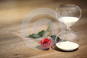 Modern hourglass and red rose with copy space.