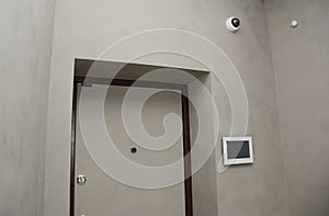 Modern house entrance door interior with smart house system, security camera, smoke alarms and fire detection. A smart home
