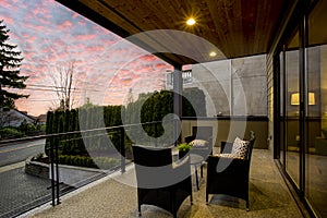 Modern house exterior with a deck at sunset.