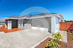 Modern house with a garage and backyard area and blue sky