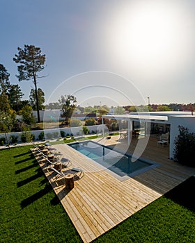 Modern house with garden swimming pool and wooden deck