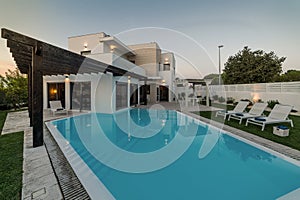 Modern house with garden swimming pool and wooden pergula