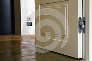 Modern house interior detail with wooden parquet floor and white door. Apartment after renovation close-up.